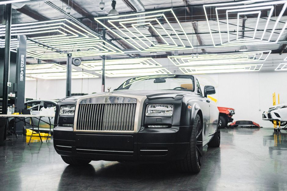 Sleek Rolls-Royce showcased in a contemporary garage with unique lighting design.